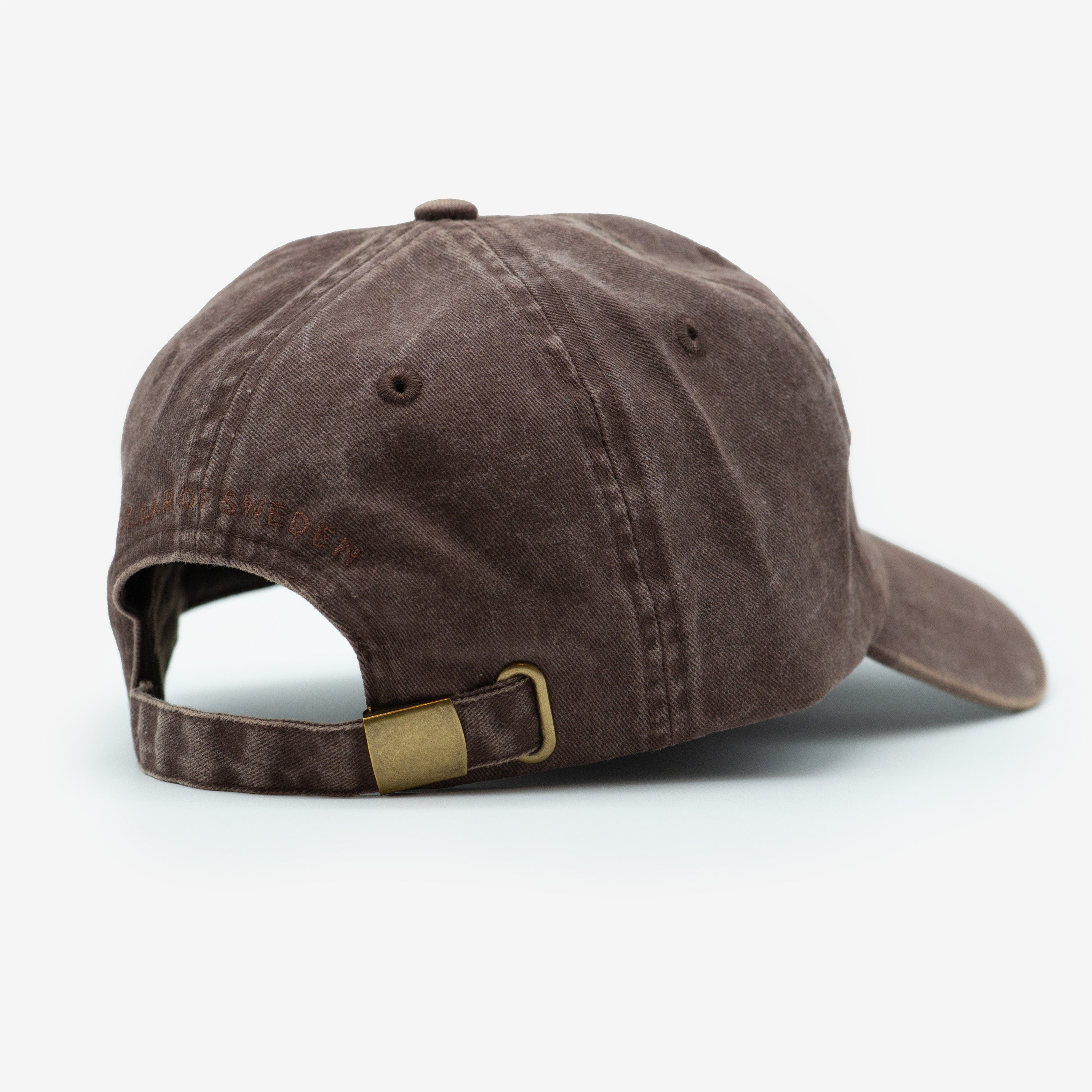 A brown denim cap with a brass buckle and adjustable strap