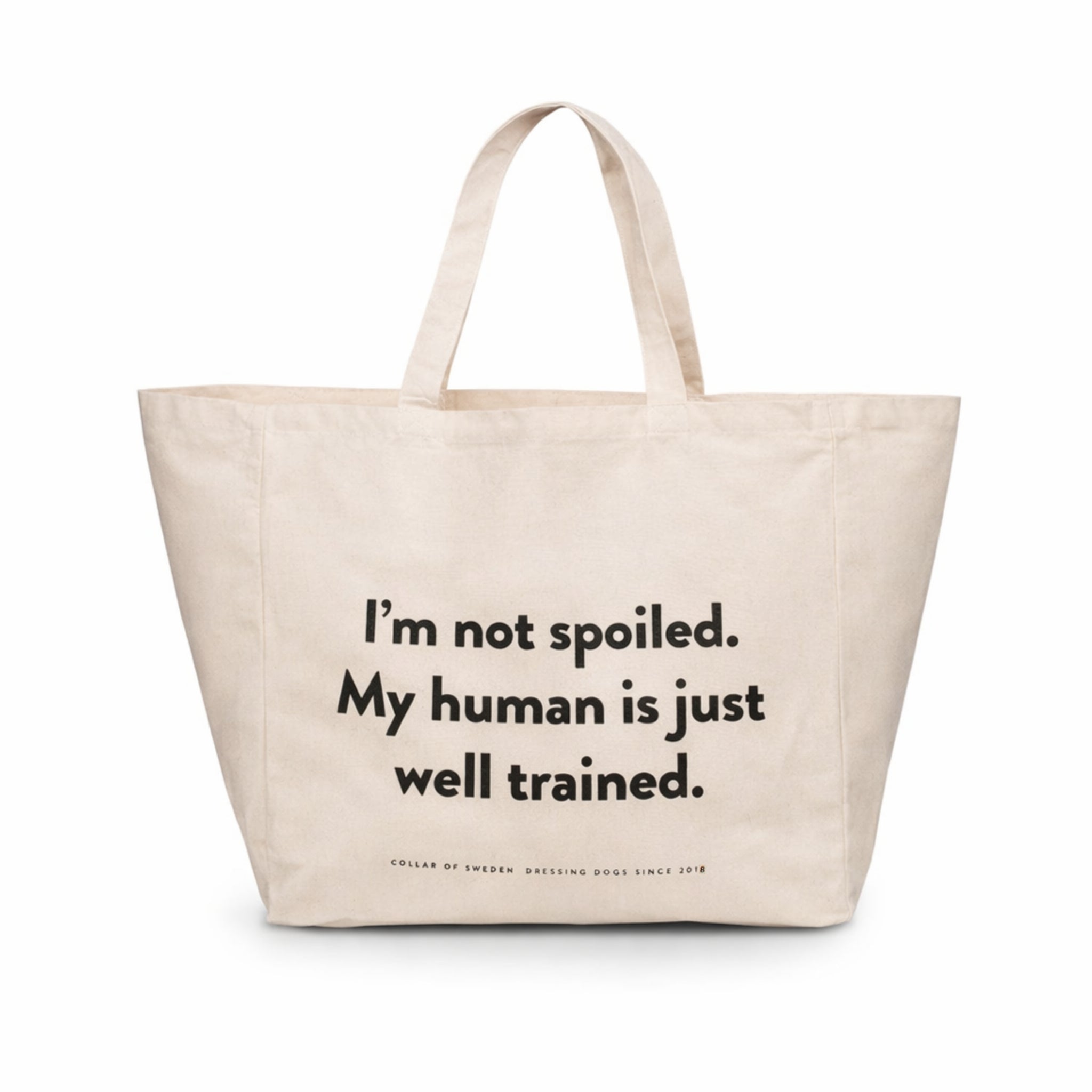 Beige large tote bag with the humorous text "I'm not spoiled. My human is just well trained. on a white background